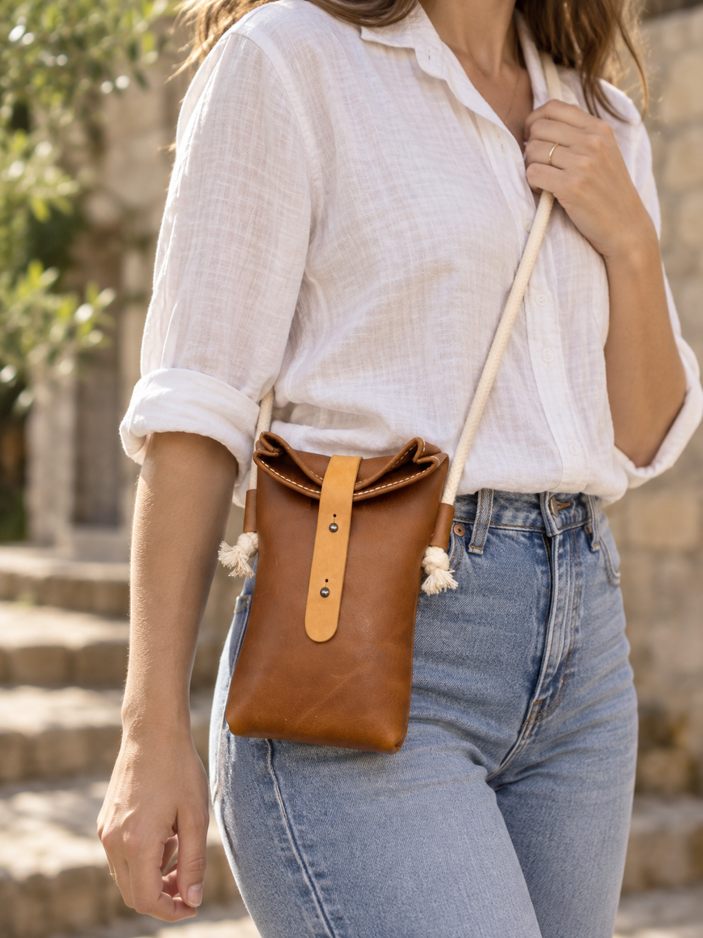 Handgefertigte Leder-Rolltop-Tasche „Mara“ mit Kordelriemen. Getragen braun